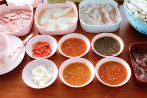 A table offering a variety of dipping sauces and condiments for the best mookata experience in Singapore.